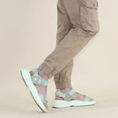 Person wearing light gray sandals and beige pants on a beige background