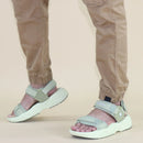 Light gray sandals worn with beige pants on a beige background